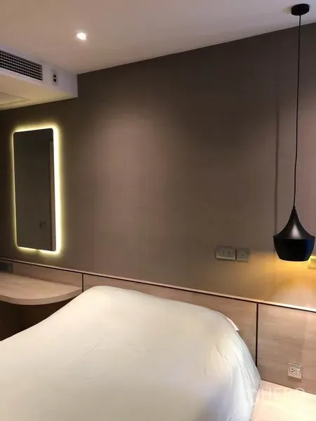 คอนโด ให้เช่าในDin Daeng, Bangkok - ผนังห้องนอนมีกระจกเงาไฟแบ็กไลท์ พร้อมแสงสลัวและหัวเตียงไม้โทนอ่อน