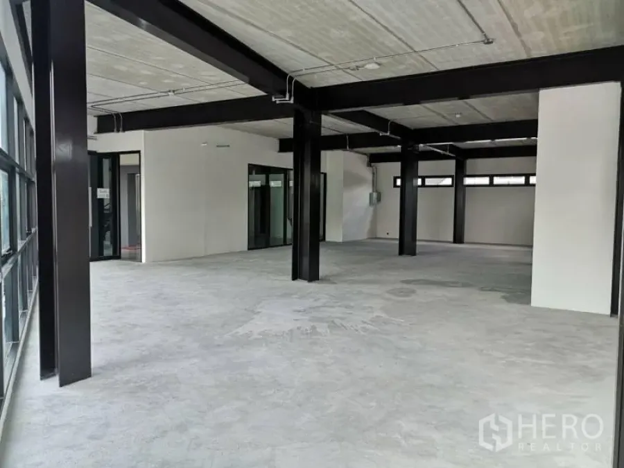 办公空间 出租在Chatuchak, Bangkok - 开放式毛坯办公室，外露顶面与黑色钢梁，水泥地面与大面积玻璃墙。