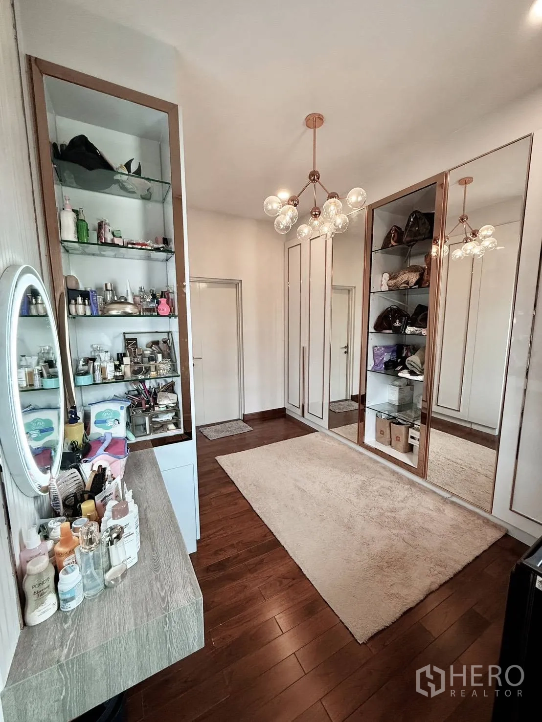 Detached House for rent in Wang Thonglang, Bangkok - Dressing room with vanity, illuminated mirror, and modern chandelier.