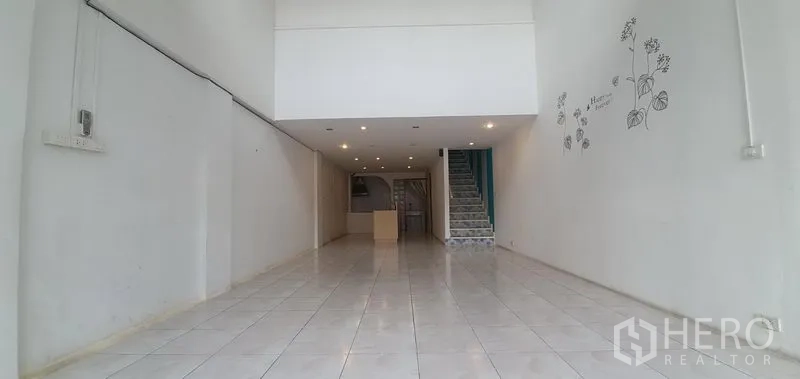 Home Office for rent in Khlong Toei, Bangkok - Long open-plan ground floor with recessed lighting and a central staircase.