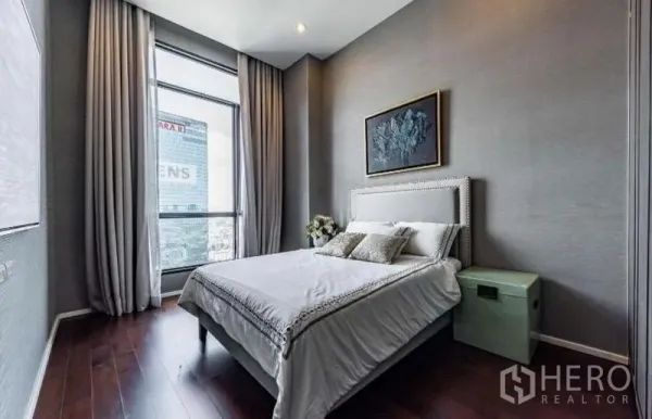 Condominium for rent - Bright guest bedroom with large window, full-length curtains and upholstered bed.