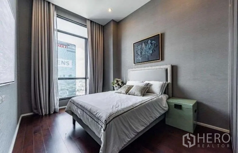 Condominium for rent - Bright guest bedroom with large window, full-length curtains and upholstered bed.
