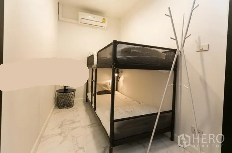 ทาวน์เฮาส์ ให้เช่าในKhlong Toei, Bangkok - ห้องอเนกประสงค์ขนาดกะทัดรัด เตียงสองชั้น ผนังสีขาว และเครื่องปรับอากาศ