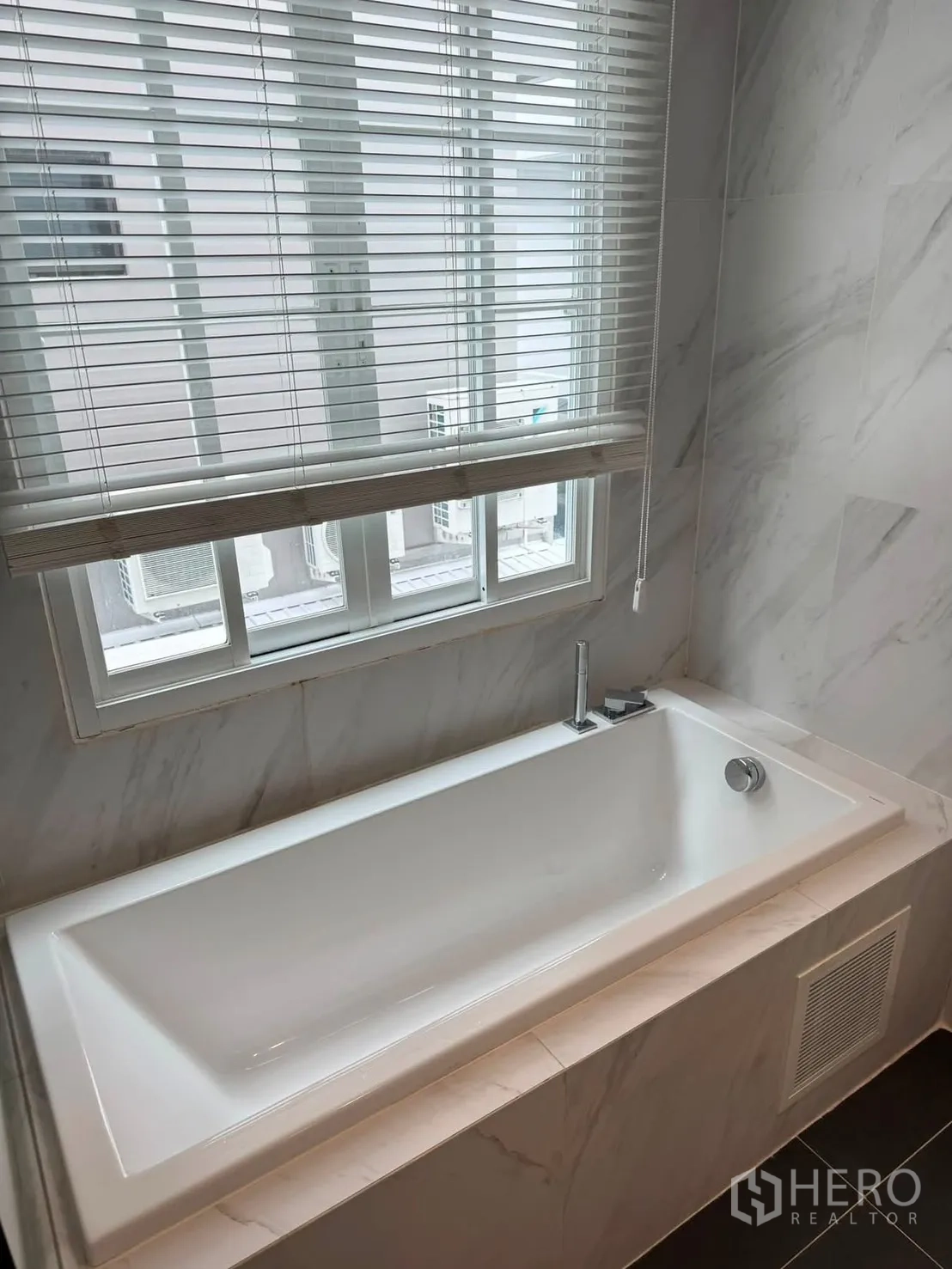 Townhouse for rent in Lat Phrao, Bangkok - Rectangular bathtub beneath a window with blinds.