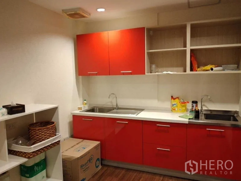 อาคารพาณิชย์ ให้เช่าในWatthana, Bangkok - มุมแพนทรีสีแดงสด มีตู้ เก็บของ อ่างล้างจานคู่ และชั้นวางเปิด.
