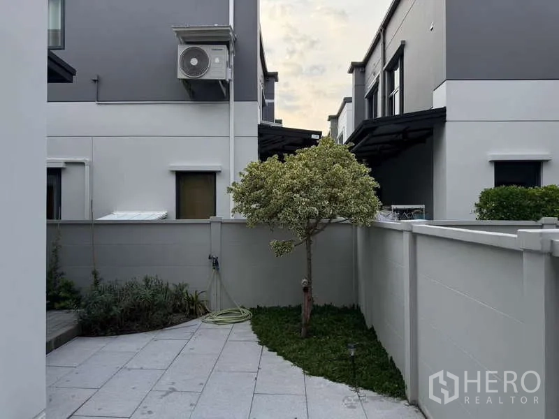 Detached House for sale in Bang Phli, Samut Prakan - Compact backyard corner with a single tree, greenery and paved area.