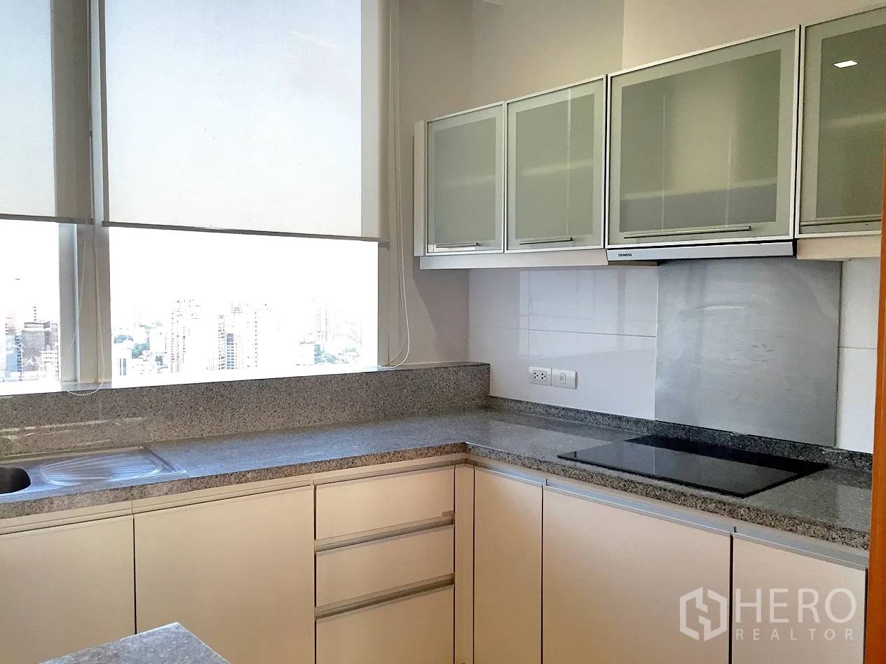 คอนโด ให้เช่าในKhlong Toei, Bangkok - ครัวแยกทรงตัวแอล เคาน์เตอร์หินแกรนิต เตาไฟฟ้า เครื่องดูดควัน และหน้าต่างบานใหญ่