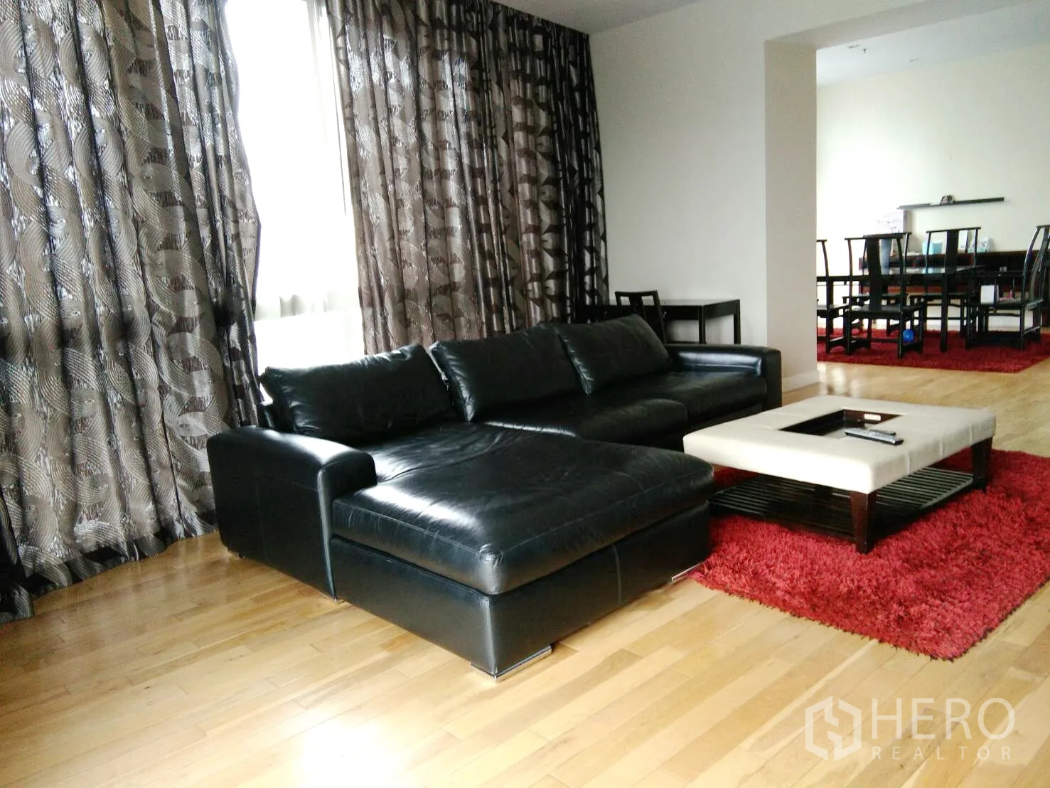 คอนโด ให้เช่าในKhlong Toei, Bangkok - ห้องนั่งเล่นกว้าง โซฟาหนังสีดำ หน้าต่างบานใหญ่และผ้าม่านลาย