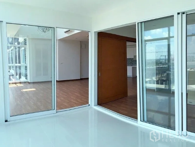 公寓 出售在Bang Na, Bangkok - 采光充足的房间，滑动玻璃门连接起居区与阳台。