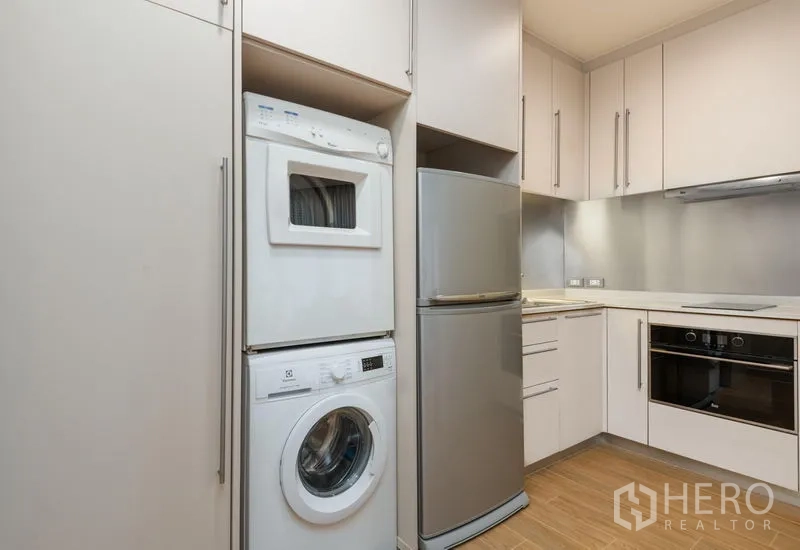 คอนโด ให้เช่าในBang Kho Laem, Bangkok - ครัวขนาดกะทัดรัด ตู้บิลท์อิน สีขาว เครื่องซักผ้าและเครื่องอบผ้าแบบซ้อน ตู้เย็นสแตนเลส เตาอบ และเตาไฟฟ้า