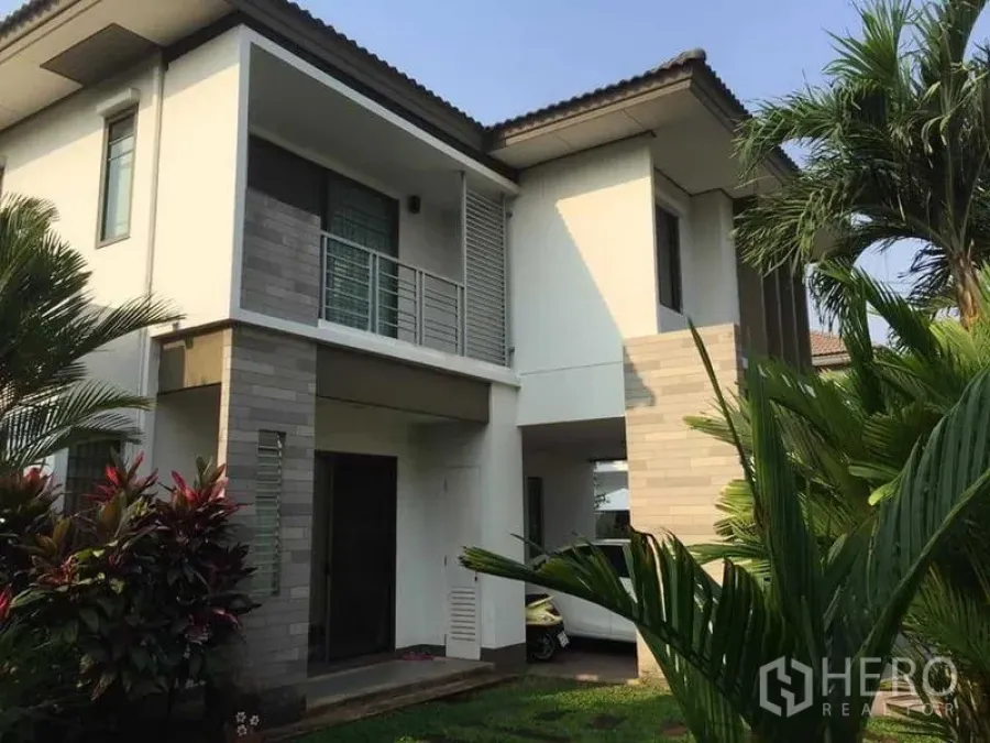 Detached House for sale in Khlong Sam Wa, Bangkok - Two-storey modern detached house exterior with balcony and tropical plants.