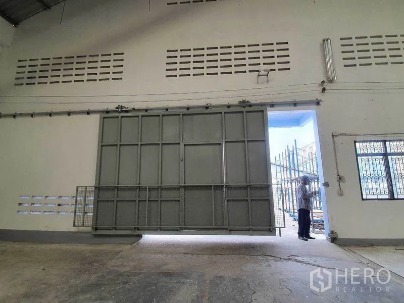 货栈 出租在Nakhon Pathom - 重型推拉大门近景，提供货车宽阔出入口。