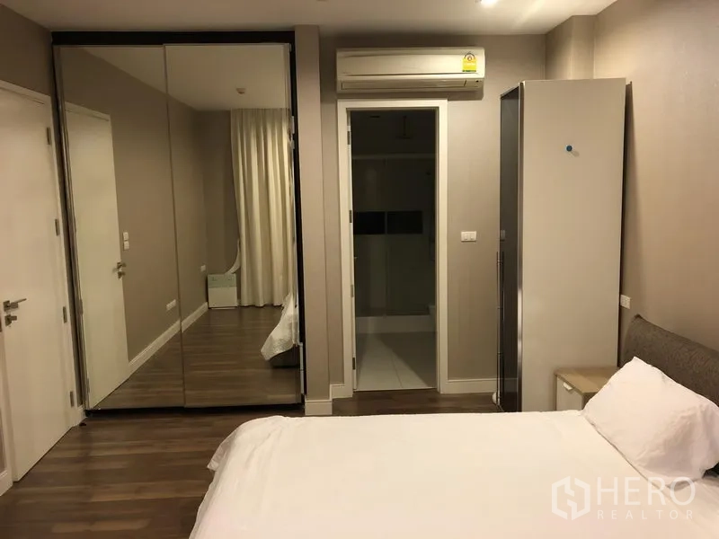 คอนโด ให้เช่าในPhra Khanong, Bangkok - ห้องนอนหลักพร้อมตู้เสื้อผ้าบานกระจก พื้นไม้ และทางเข้าห้องน้ำในตัว