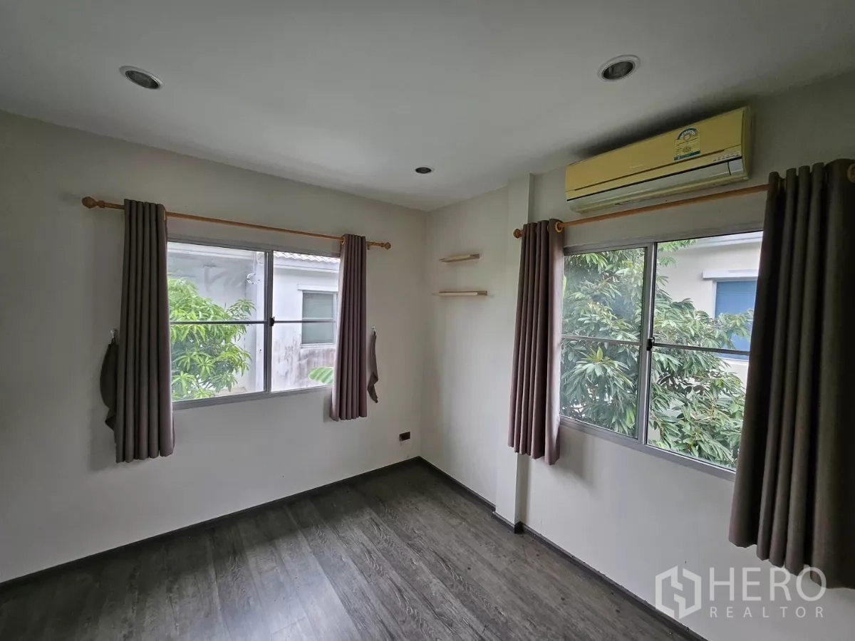 独立式住宅 出租在Khlong Toei, Bangkok - 次卧设两扇窗、空调与木纹地板。