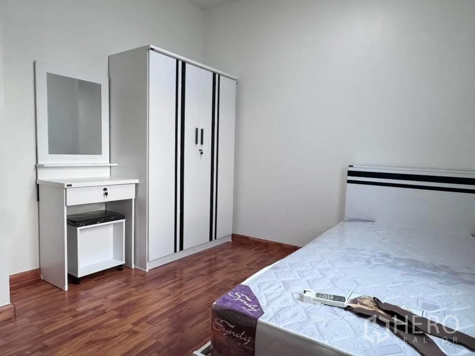 联排别墅 for rent in Phra Khanong, Bangkok - 卧室配衣柜、梳妆台与床，木地板铺设。