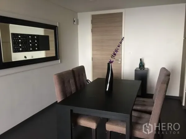 Condominium for rent or sale in Bang Lamung, Chon Buri - Close-up of a four-seat dining table with wall mirror and minimalist decor.