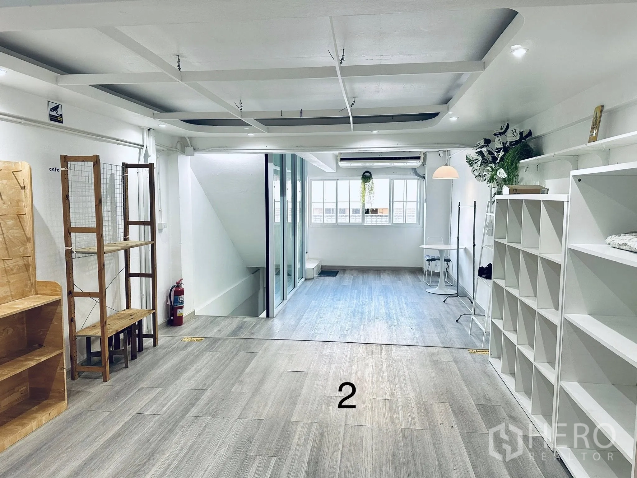 店屋 for rent in Watthana, Bangkok - 开放式楼层，木纹地板、展示架、玻璃隔断与窗户。