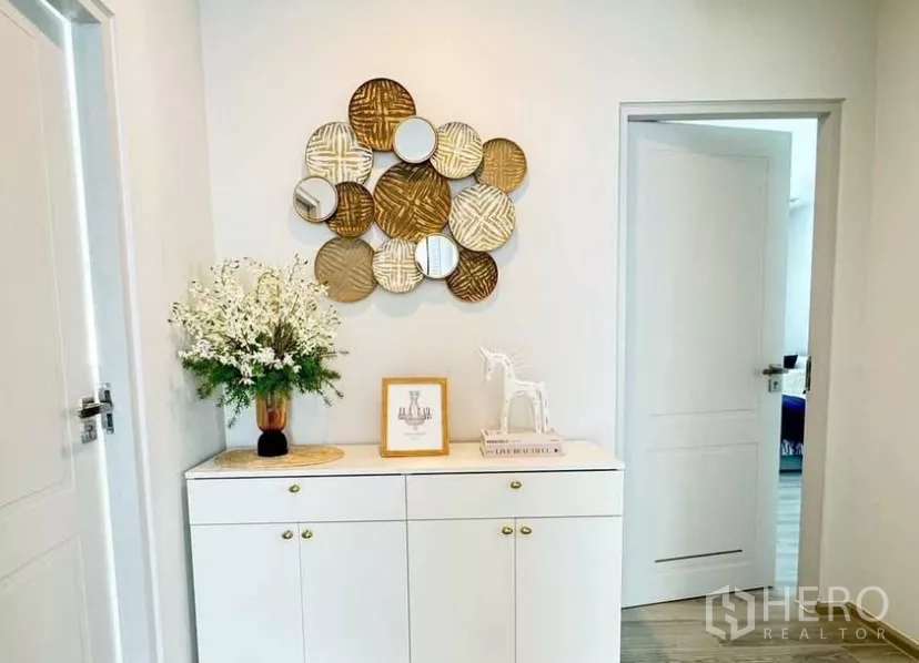 Detached House for rent in Bang Phli, Samut Prakan - Upstairs hall cabinet with decorative wall art and flowers.