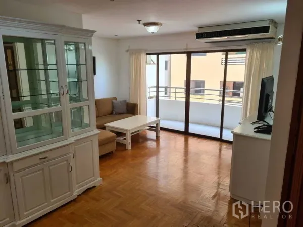 คอนโด ให้เช่าในWatthana, Bangkok - ห้องนั่งเล่นพื้นปาร์เกต์ โซฟา ตู้ทีวี และประตูกระจกสไลด์ออกสู่ระเบียง