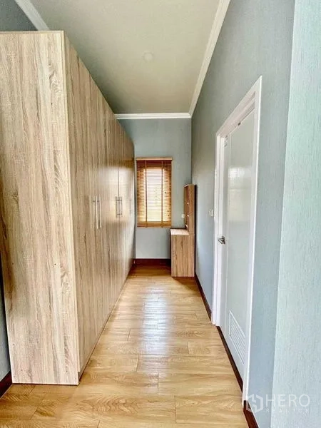 Detached House for rent in Khlong Sam Wa, Bangkok - Walk-in wardrobe corridor with tall cabinets and dressing table