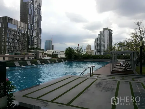 คอนโด ให้เช่าในKhlong Toei, Bangkok - สระว่ายน้ำกลางแจ้งพร้อมเตียงนอนเล่นและวิวอาคารเมือง