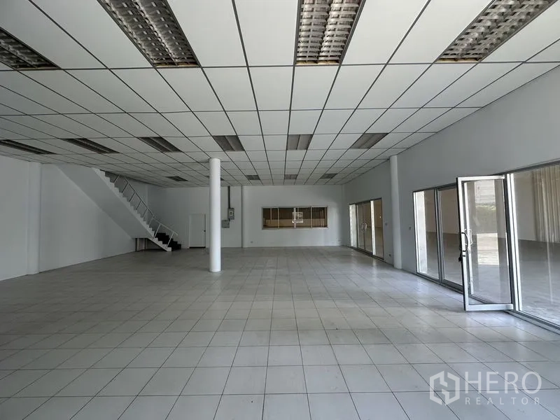 工厂 出租在Khlong Luang, Pathum Thani - 一层办公室，瓷砖地面、格栅吊顶与玻璃隔断。