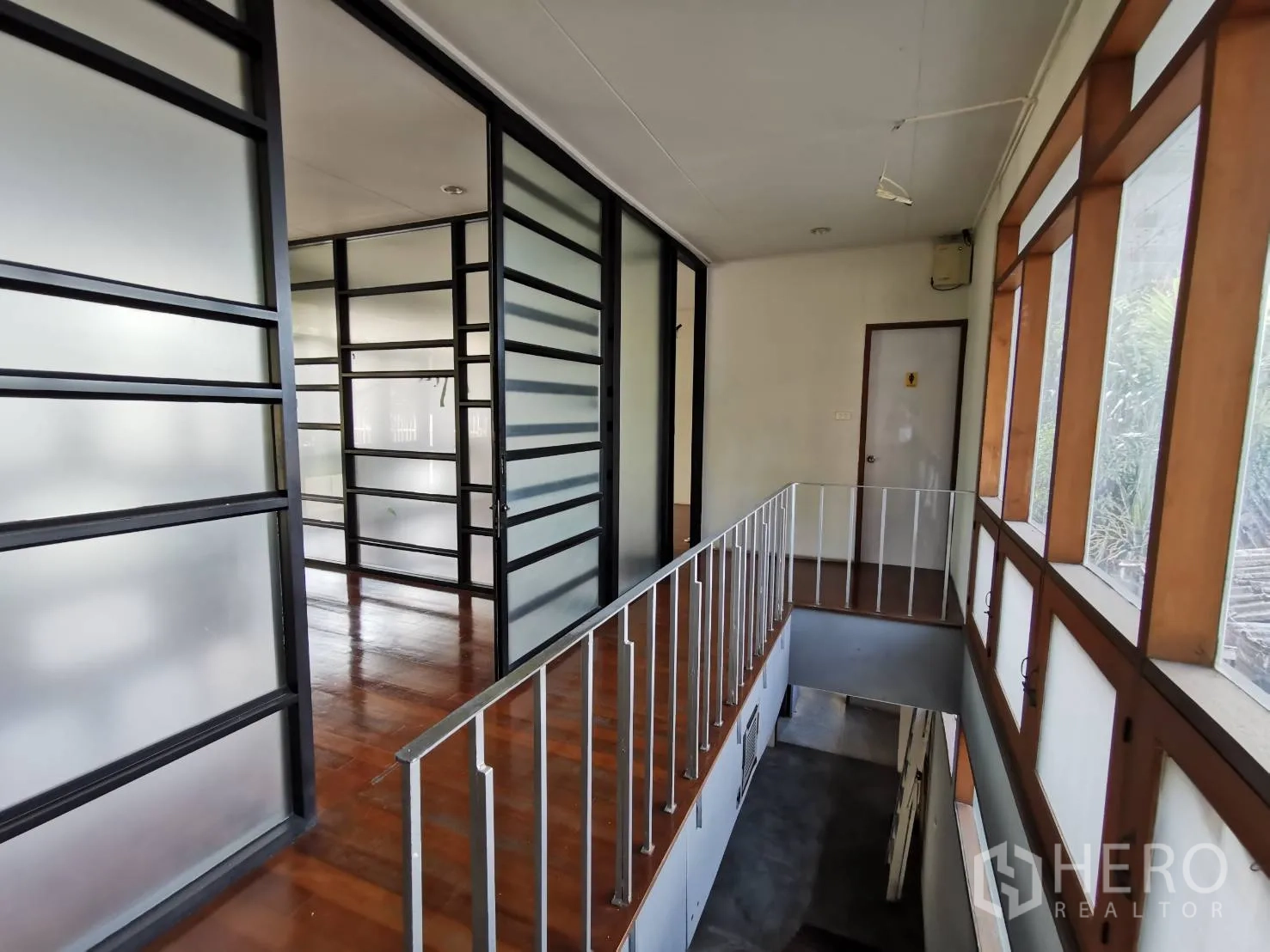 Home Office for rent in Watthana, Bangkok - Upper hallway with frosted-glass partitions and wood-framed windows.