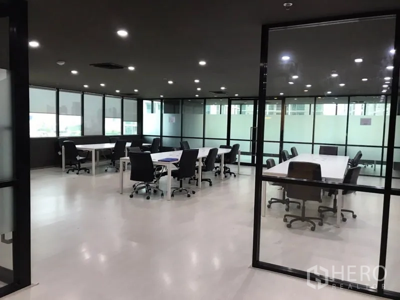 Office Space for rent in Watthana, Bangkok - Large glass-walled office area with multiple meeting tables and task chairs.
