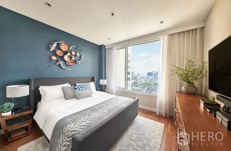 คอนโด ให้เช่าหรือขายในSathon, Bangkok - ห้องนอนหลักผนังสีน้ำเงิน เตียงคิงไซส์ หน้าต่างบานใหญ่เห็นวิวเมือง