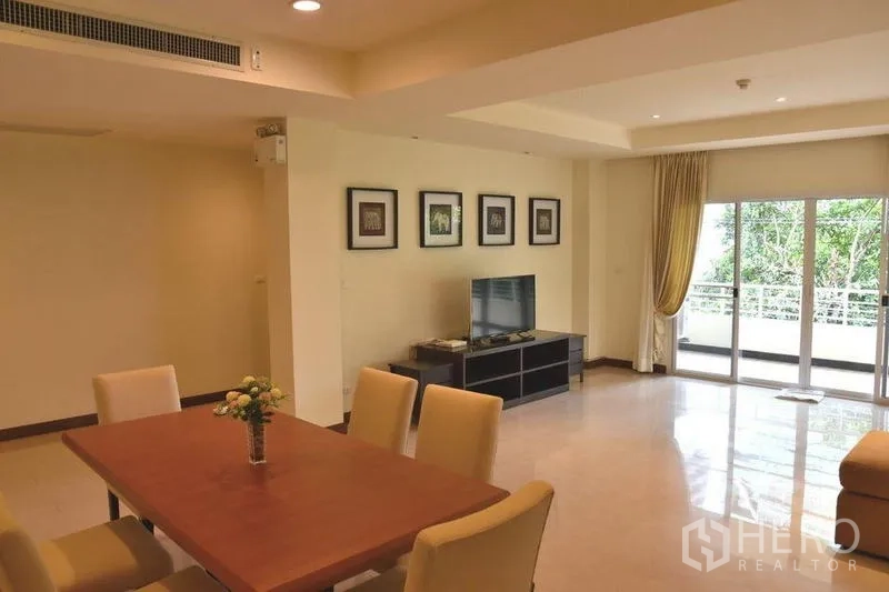 房间 出租在Sathon, Bangkok - 餐区与客厅相连，宽阳台享绿意景观。