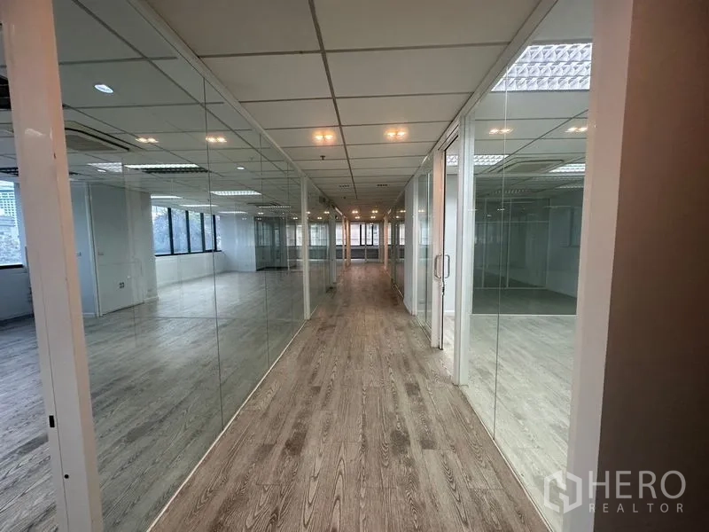 办公空间 出租在Din Daeng, Bangkok - 玻璃办公室成排的走廊，木纹地面。