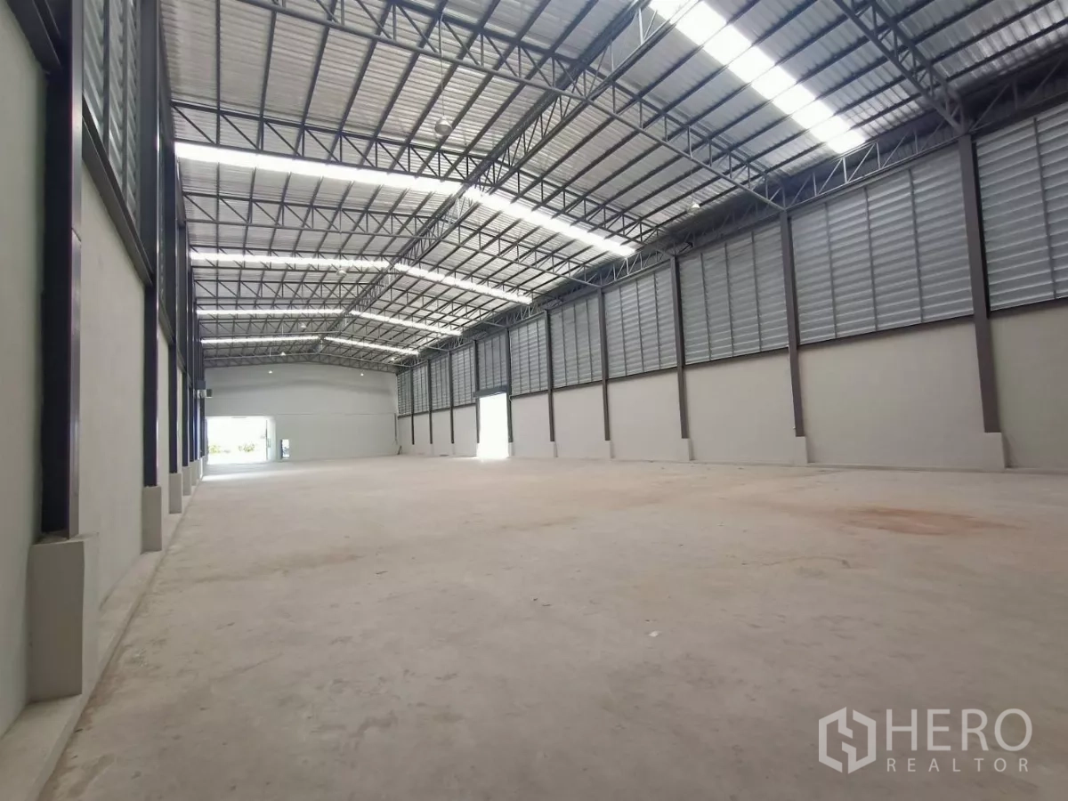 工厂 出租或出售在Mueang Samut Sakhon, Samut Sakhon - 仓库内部挑高空间，钢结构屋架，采光带与侧向通风百叶。