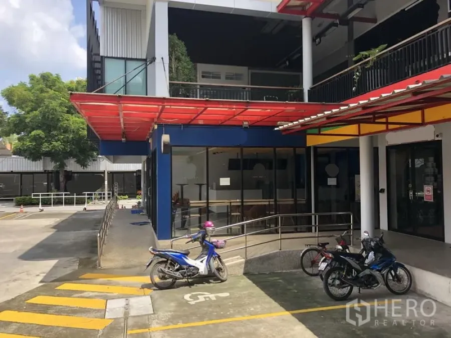 零售空间 出租在Wang Thonglang, Bangkok - 曼谷旺通朗区一层临街商铺，红色雨棚、玻璃门面、无障碍坡道及摩托车停车位。