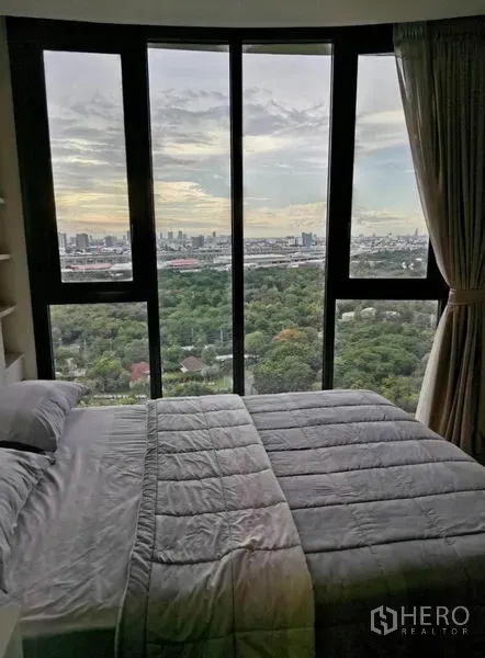 Condominium for rent - Bedroom with curved floor-to-ceiling windows, king bed and panoramic green park and city views.