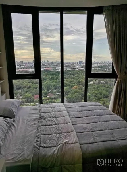 Condominium for rent - Bedroom with curved floor-to-ceiling windows, king bed and panoramic green park and city views.