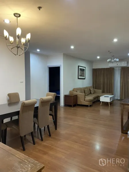 公寓 出租在Watthana, Bangkok - 开放式客餐厅，木地板、吊灯与L型沙发。