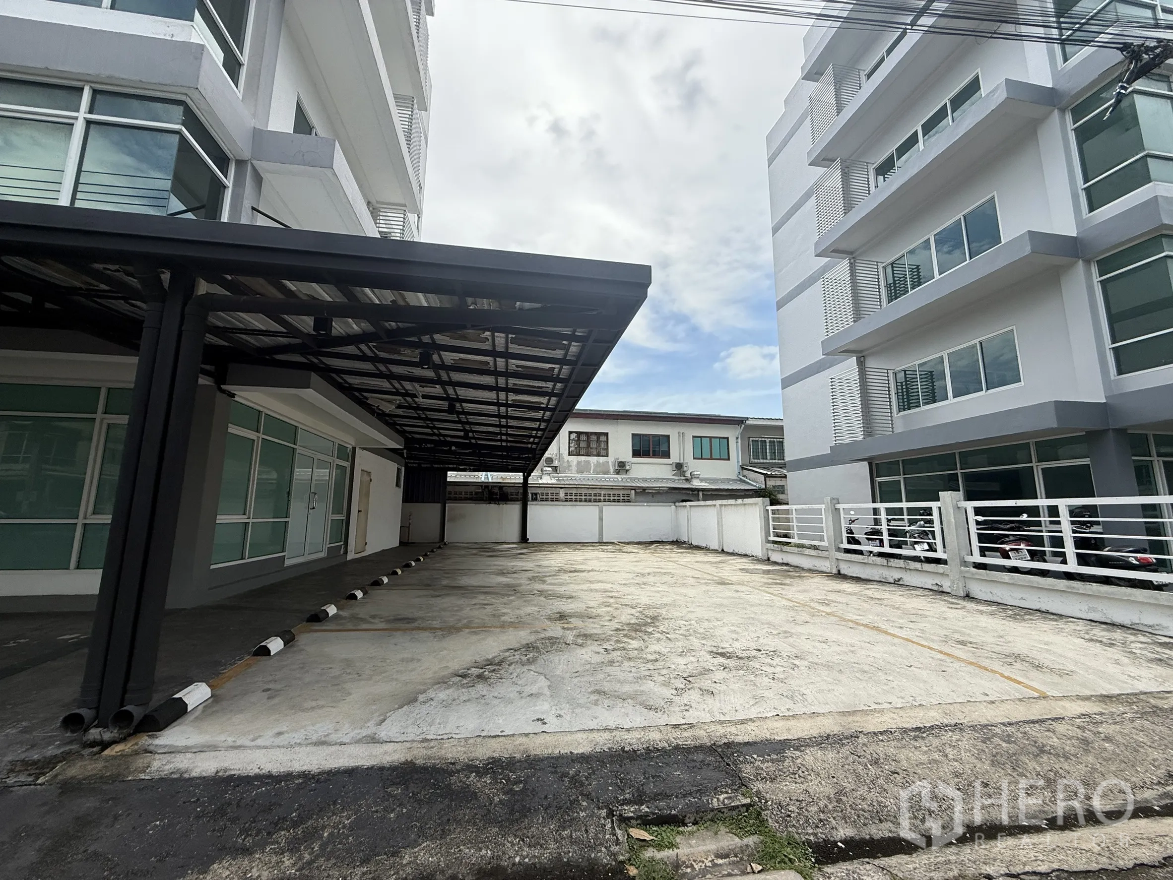 สำนักงาน ให้เช่าในBueng Kum, Bangkok - ลานจอดรถกว้างขวางข้างอาคารสำนักงานสมัยใหม่และรั้วล้อมรอบ