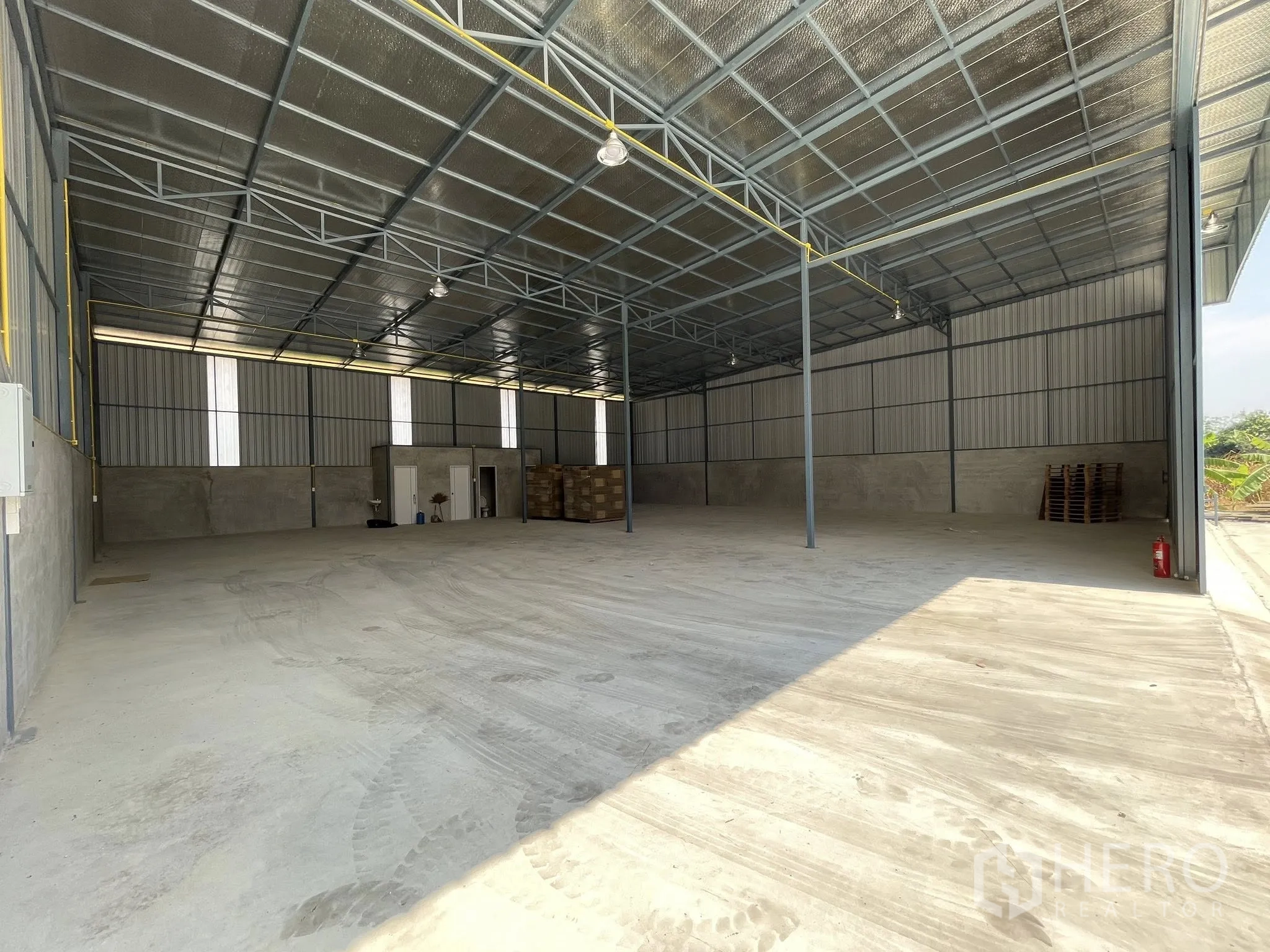 Warehouse for rent in Bang Phli, Samut Prakan - Interior view with insulated roof, support columns, and rear utility rooms.