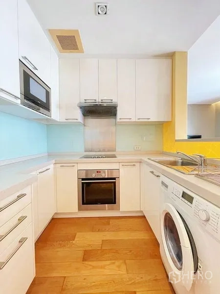 คอนโด ให้เช่าในWatthana, Bangkok - ครัวรูปตัวยูสมัยใหม่ ตู้สีขาว เตาอบ เตาไฟฟ้า ไมโครเวฟ และเครื่องซักผ้า