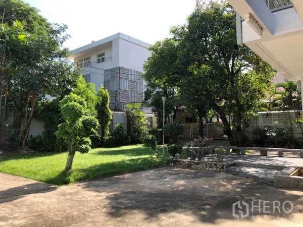 独立式住宅 出租在Phra Khanong, Bangkok - 两层独立屋的前庭花园，草坪与成树及铺装露台，环境清幽。