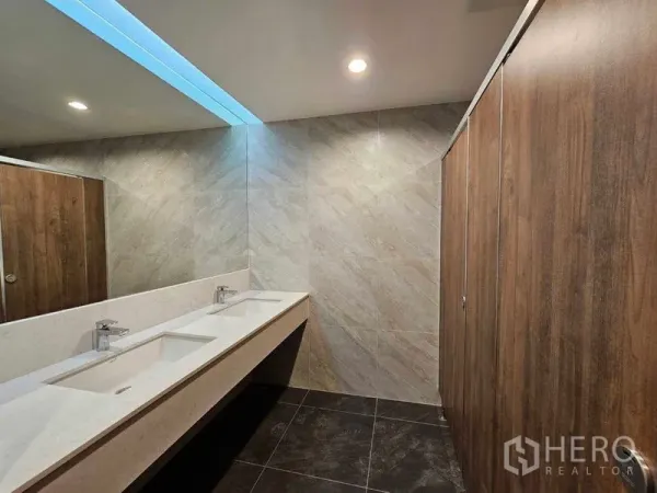 办公空间 出租在Bang Rak, Bangkok - 现代化卫生间，双洗手台、石材墙面与木质隔间。