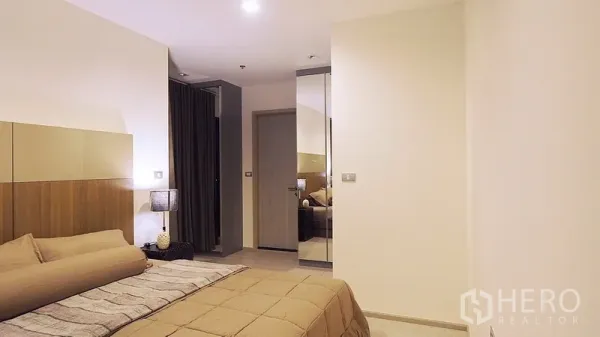 คอนโด ให้เช่าหรือขายในKhlong Toei, Bangkok - ห้องนอนที่สองโทนอบอุ่น เรียบหรู พร้อมหัวเตียงบิวท์อิน โคมไฟข้างเตียง และตู้เสื้อผ้ากระจก