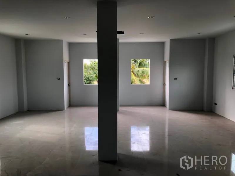 Factory for rent or sale in Khlong Luang, Pathum Thani - Upper-level office room with tiled floor, central support column, and multiple windows.