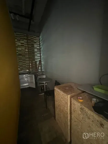 零售空间 出租在Khlong Toei, Bangkok - 后勤区走道带小茶水间、木箱与百叶格栅采光。