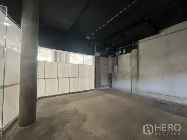 零售空间 出租 - 毛坯室内空间，混凝土地面、黑色外露天花与管线接口。