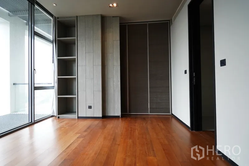 公寓 出租在Sathon, Bangkok - 卧室连接阳台，内置书架与大衣柜，铺设木地板。