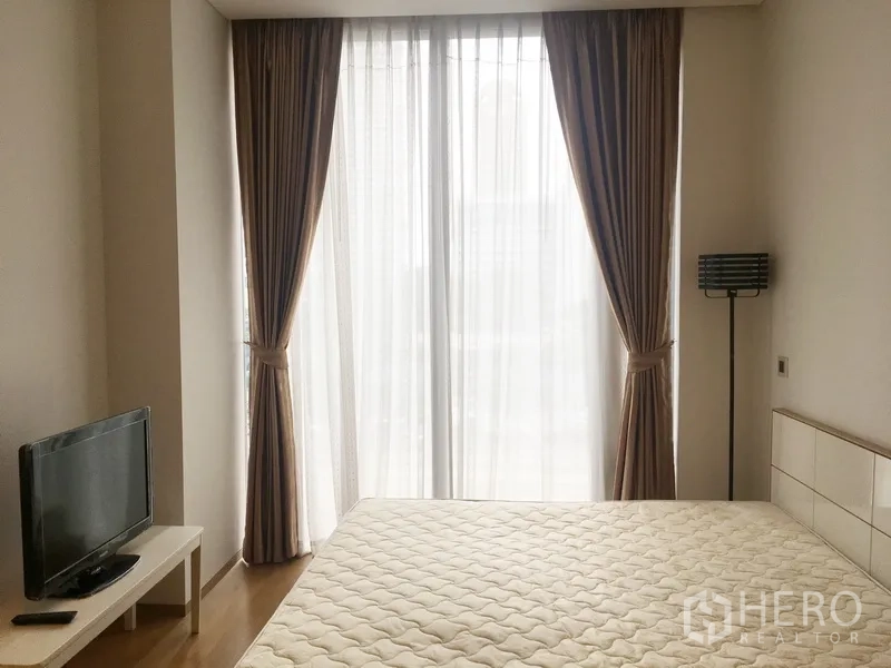 คอนโด ให้เช่าในBang Rak, Bangkok - ห้องนอนรับแสงธรรมชาติ มีหน้าต่างบานใหญ่พร้อมม่าน เตียงควีน ทีวี และโคมยืน