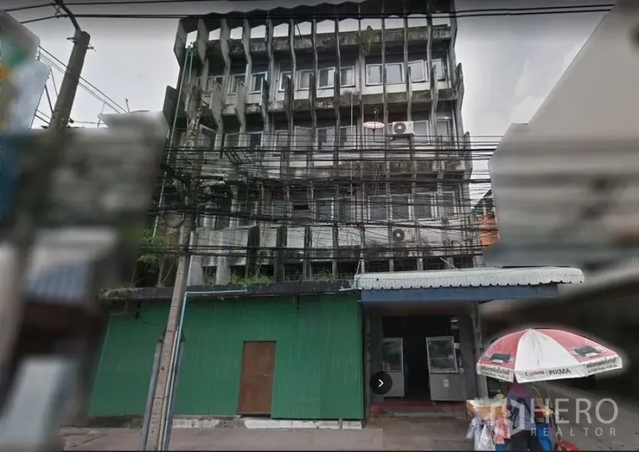 店屋 出租或出售在Yan Nawa, Bangkok - 曼谷街道上的多层混凝土商铺外立面，方格窗、金属雨棚、外挂机与密集的架空电线
