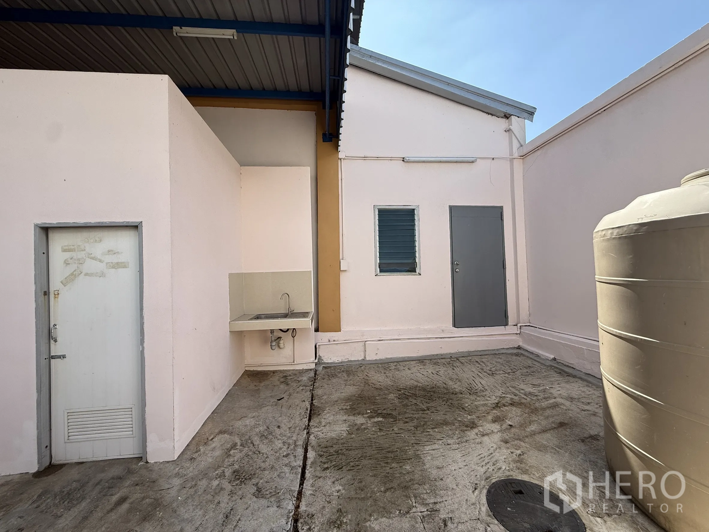 Warehouse for rent or sale in Bang Bo, Samut Prakan - Rear service yard with utility room, sink and water tank.