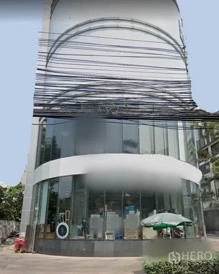 零售空间 出租在Watthana, Bangkok - 曼谷瓦塔那区转角零售建筑，双层弧形玻璃立面与临街落地窗。